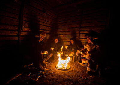 A group of Kazakh Eagle Hunters sitting by the bonfire and drinking soup to keep themselves warm.