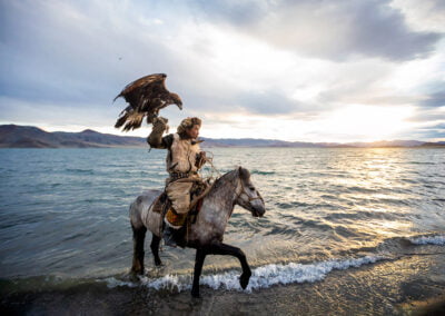 Barzabai,a famous eagle hunter, with his eagle and horse on Tolbo lake which is a freshwater lake located 45 km south-east of Ulgii town.
