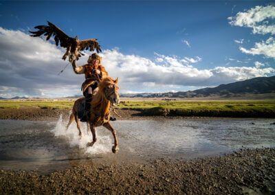 Botei Rys, a Kazakh Eagle Hunter crossing a river with his eagle from Altantsögts district of Bayan-Ölgii Province in western Mongolia.