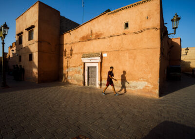 A man walking on the streets of Morocco in the evening.