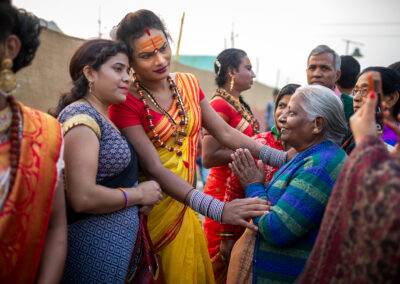 A transgender sadhu of the Kinnar Akhada with devotees during Ardh Kumbh Mela in Prayagraj. In a historic first during the 2019 Kumbh Mela, a group of transgender sadhus, known as the Kinnar Akhada, made their debut. Led by transgender activist Laxmi Narayan Tripathi, a former reality TV star and prominent activist known for her distinctive tattoos, the group's members adorn themselves in vibrant sarees and jewellery, making a striking appearance at the festival. Traditionally, akhadas have been male-dominated, with no akhadas led by cisgender women and only a few women ascetic members in certain groups. However, the transgender religious order was embraced by the Juna Akhada, the oldest and largest of the 13 sects that establish camps at every Kumbh to conduct prayers, religious lectures, and blessings for visitors. Inclusion in the Juna Akhada granted transgender members the privilege to participate in the royal holy dip (shahi snan) on auspicious days at the confluence of rivers in Prayagraj, ahead of millions of other pilgrims.