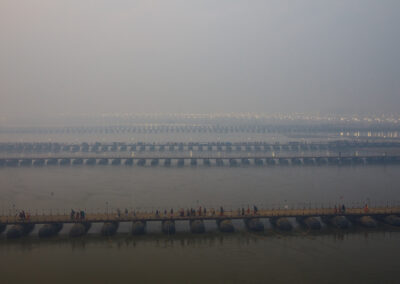 Pontoon Bridge. The preparations include constructing at least 22 temporary pontoon bridges to accommodate the influx of pedestrians, vehicles, and animals expected to arrive on the riverbanks. Notably, in 2019, bridge number 19, the longest pontoon bridge in the history of the Kumbh, stretched 1.1 kilometers across the Ganga, connecting the Naini and Chatnag sides of the river. This bridge comprises 230 pontoons and is situated near Chatnag Ghat. Over 1,800 floating steel pontoons are currently undergoing repairs, construction, and installation, with decking being added as thousands of workers gear up for the event.