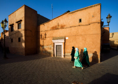 Three ladies are walking on the streets of Morocco in the evening.