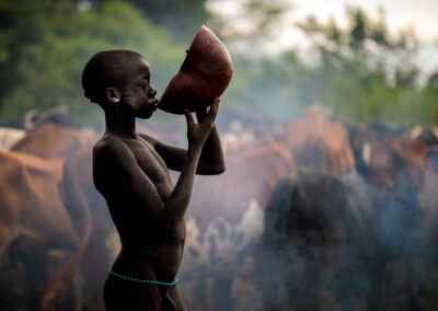 A young Suri tribe boy from Omo Valley, Ethiopia is drinking the blood of a cow.