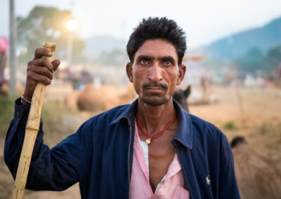 A camel shepherd is moving with his camel during Pushkar Mela, Rajasthan.