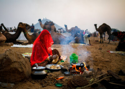 Wife of a camel herder is preparing food during Pushkar Mela, Rajasthan.